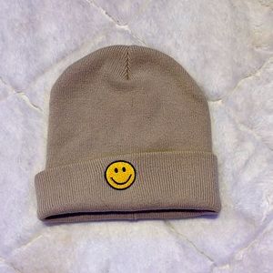 Tan beanie with a smiley face in front.